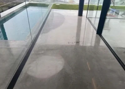 Polished concrete pool surround in Manly with glass balustrade