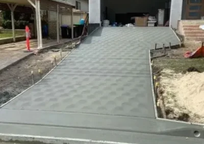 Stamped concrete driveway in Curl Curl leading up to a garage with a tiled pattern finish